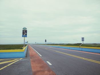 Road sign against sky