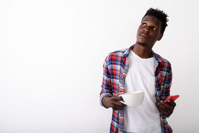 Man holding coffee cup against white background