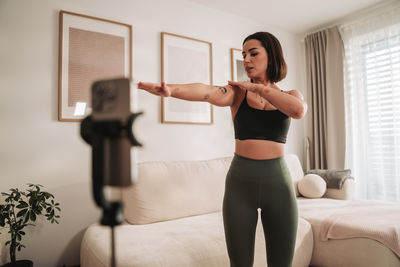 Portrait of young woman exercising at home