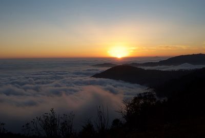 Sunset on mountain top above clouds