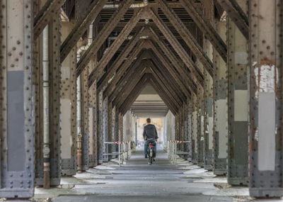 Rear view of people walking in corridor of building