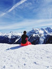 Man on snowcapped mountain against sky during winter