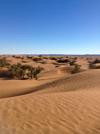 Scenic view of desert against clear blue sky