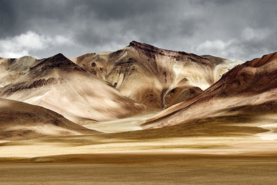 Deserted landscape of mountains with storm clouds in the sky, the sun light created high contrast