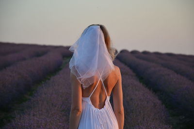 Rear view of woman standing on field