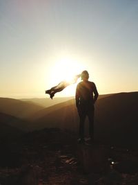 Silhouette man standing on mountain against clear sky