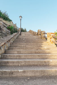 Low angle view of steps amidst street against clear sky