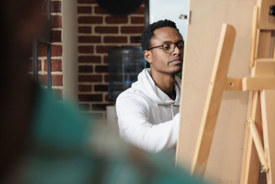 Young man painting on canvas