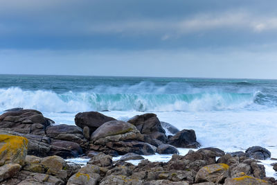 Waves hit the rocks in rough seas. on a cloudy day. galicia spain.