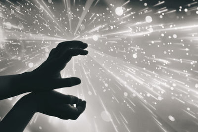 Low angle view of person touching illuminated light