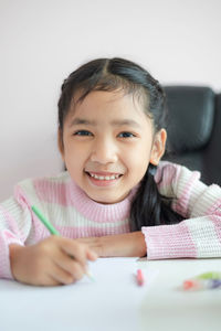 Portrait of cute girl smiling on table