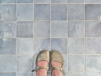 Low section of woman standing on tiled floor