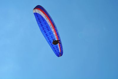 Low angle view of kite in blue sky