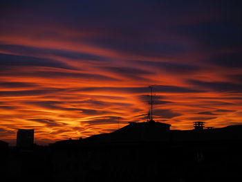 Silhouette of city against sky during sunset