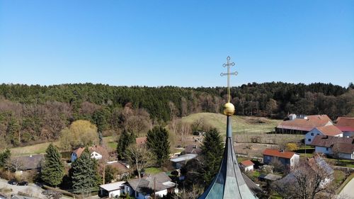 High angle view of trees and buildings against clear blue sky