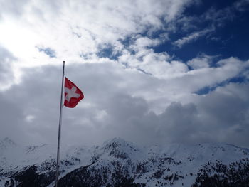 Swiss flag against snowcapped mountains