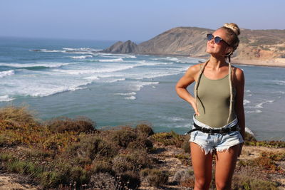 Full length of young woman standing on beach