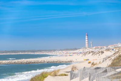 Lighthouse by sea against sky