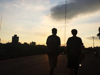 Silhouette of people in city at sunset