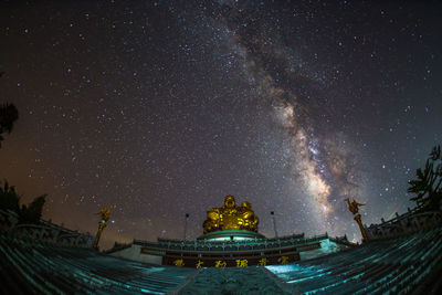 Low angle view of illuminated building against sky at night