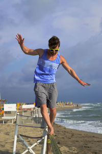 Man slacklining on beach