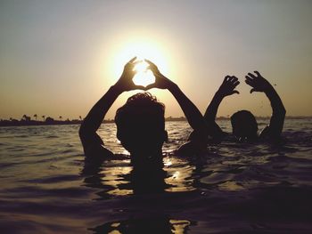 Silhouette of couple in the sea at sunset