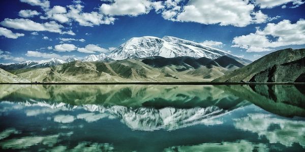 Scenic view of lake and snowcapped mountains against sky