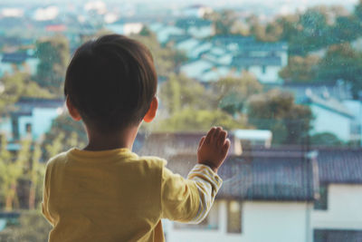 Rear view of boy looking at camera