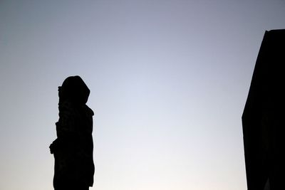 Low angle view of silhouette statue against clear sky