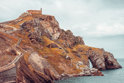 Rock formations in sea against sky