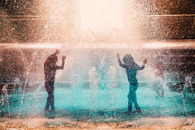 People dancing under fountain
