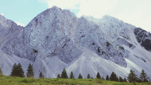 Low angle view of snowcapped mountains against sky