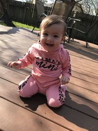 Portrait of smiling girl sitting outdoors