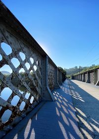 Tilt image of bridge against clear blue sky