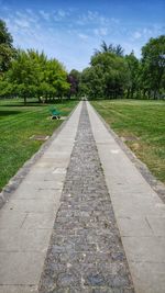 View of footpath in park against sky