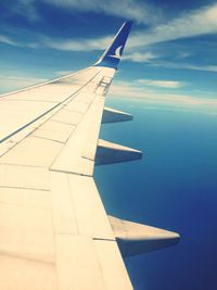 Cropped image of airplane flying over clouds