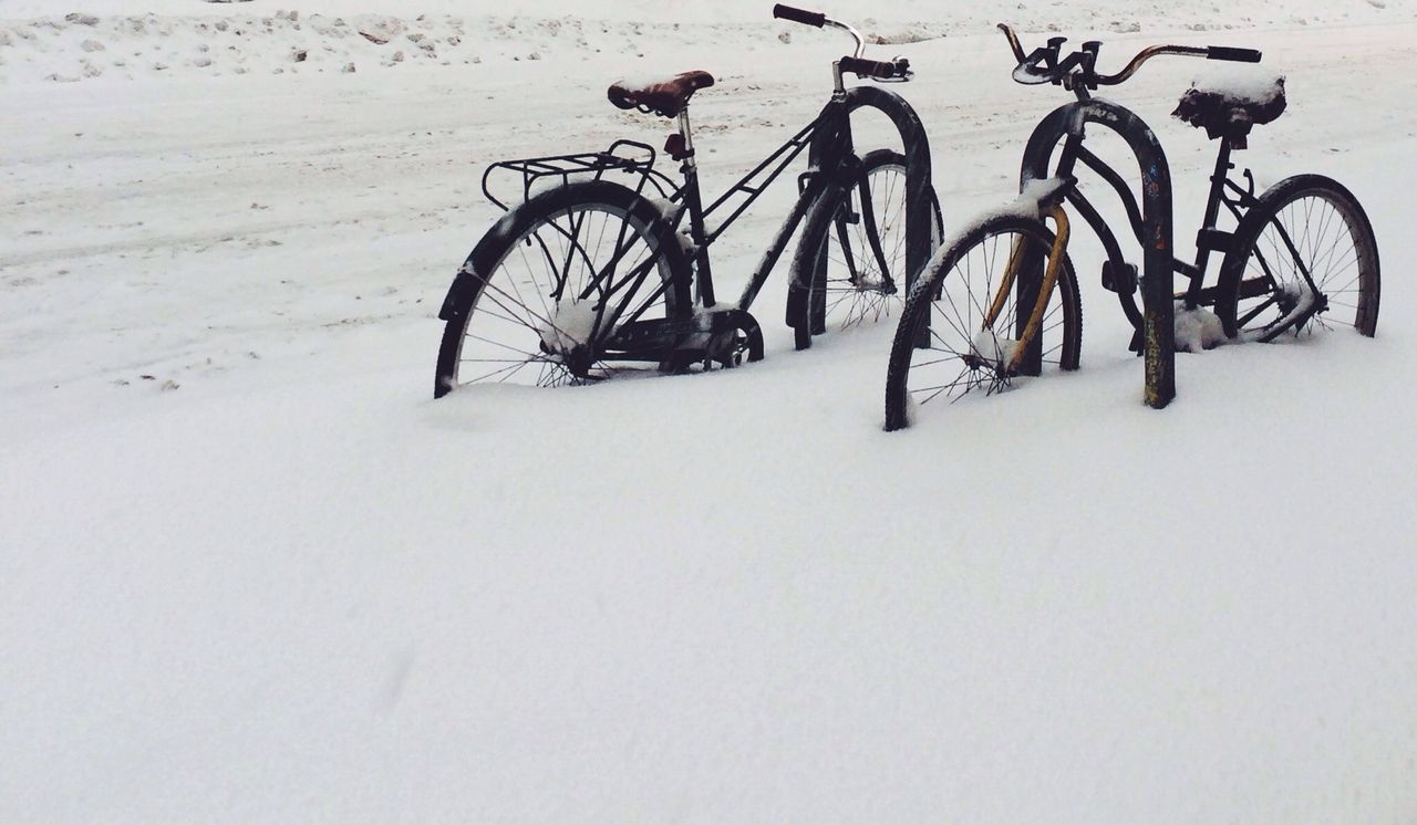 bicycle, land vehicle, transportation, mode of transport, stationary, parked, parking, wheel, shadow, no people, wall - building feature, day, outdoors, high angle view, absence, copy space, sunlight, snow, street, wall