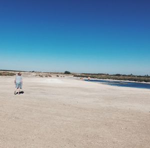 Man on beach against clear blue sky