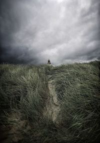 Scenic view of land against cloudy sky