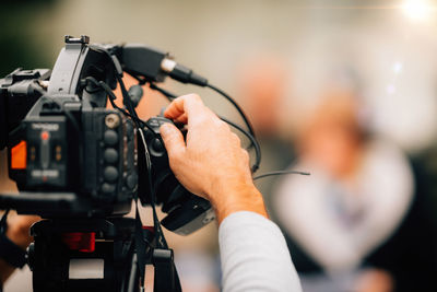 Tv camera at a press conference, capturing a video of an unrecognizable speaker