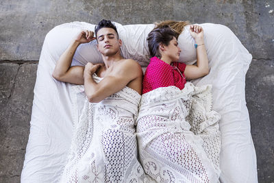 High angle view of friends lying on bed