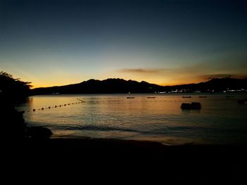 Scenic view of lake against clear sky during sunset