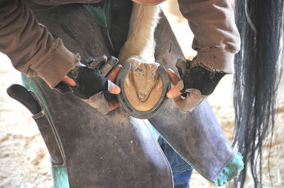 Midsection of men holding horse shoe