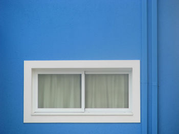 Closed window on blue building