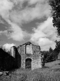 Old ruin building on field against sky