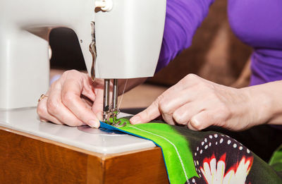 Midsection of woman using sewing at workshop