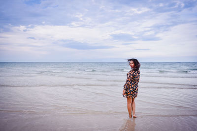 Full length of man standing on beach against sky