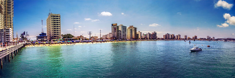 Panoramic view of sea and buildings against sky