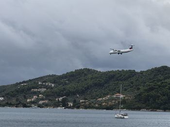 Airplane flying over sea against sky