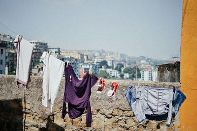 Clothes drying on clothesline against buildings in city